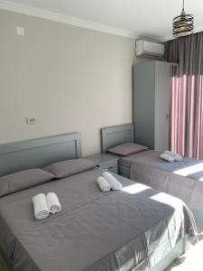 1 dormitorio con 2 camas y toallas. en Sunrise Ureki en Ureki
