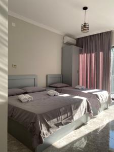 sypialnia z 2 łóżkami i oknem w obiekcie Sunrise Ureki w mieście Ureki