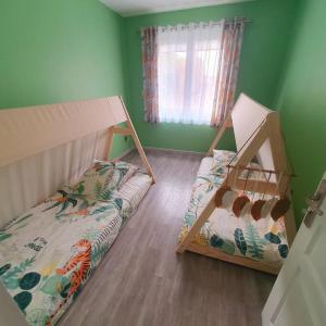マリニャーヌにあるJoli haut de villa 3 chambres climatisé avec jacuzziの緑の壁のドミトリールームの二段ベッド2台