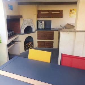 a kitchen with a table and a pizza oven at Joli haut de villa 3 chambres climatisé avec jacuzzi in Marignane