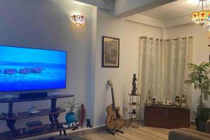 a living room with a large flat screen tv at Hibiscus Home Stay & Boutique in Port Blair