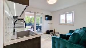 a kitchen and living room with a couch and a sink at Villa Apartments Marko & Šimun in Kaštela