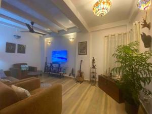 a living room with a couch and a flat screen tv at Hibiscus Home Stay & Boutique in Port Blair