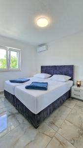 - un grand lit dans une chambre blanche avec 2 oreillers dans l'établissement Villa Apartments Marko & Šimun, à Kaštela