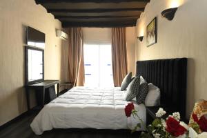Agyad Maroc Appart-Hotel في أغادير: غرفة نوم بسرير ابيض ونافذة