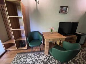 um quarto com uma mesa e duas cadeiras e uma televisão em Private em Shchūchīnsk