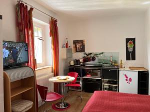 a living room with a small table and a kitchen at Radstation Menz in Menz