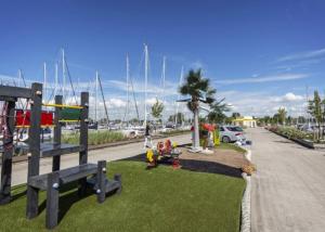 een park met een speeltuin met boten in een jachthaven bij Chalet ‘De Sânkop’ in Makkum