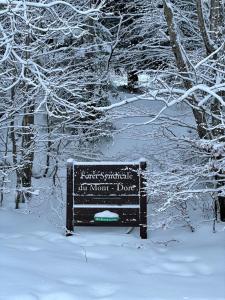 a sign in the snow next to some trees at Les Longes in Le Mont-Dore