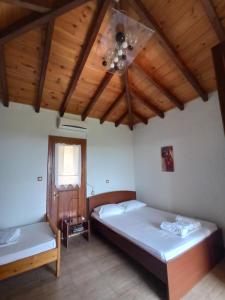 a bedroom with two beds and a wooden ceiling at Katerina's Houses #2 in Alonnisos Old Town