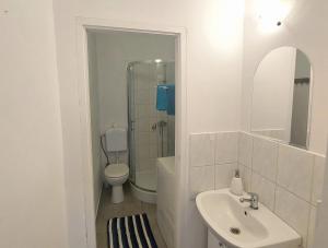 a white bathroom with a sink and a toilet at Kawalerka w centrum Sopotu in Sopot