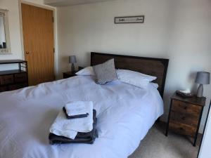 Un dormitorio con una cama blanca con toallas. en Holiday Let Mistley, en Mistley