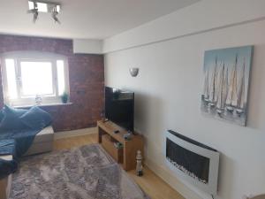 a living room with a bed and a flat screen tv at Holiday Let Mistley in Mistley