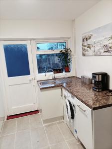 a white kitchen with a sink and a dishwasher at Pace home in Bristol