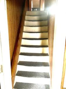 Una escalera que conduce a una habitación con escaleras blancas en Nice House in centrum., en Frederikshavn