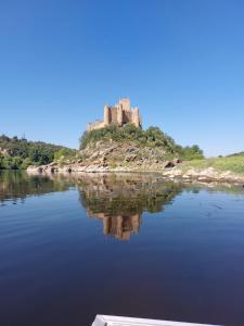 a castle on an island in a body of water at Casa da Avó Bi in Vila Nova da Barquinha