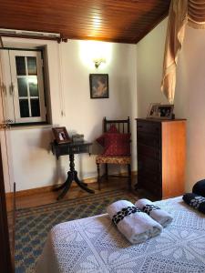 a bedroom with a bed and a dresser and a window at Casa da Avó Bi in Vila Nova da Barquinha +20 photos