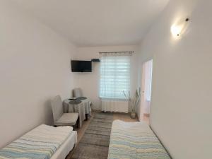 Zimmer mit 2 Betten, einem Tisch und einem Fenster in der Unterkunft Kawalerka w centrum Sopotu in Sopot