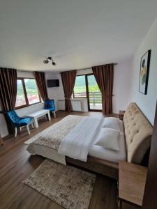 1 dormitorio con 1 cama grande y 1 sofá en Agropensiunea La Uța, en Rebrişoara