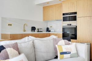 a living room with a white couch with pillows at Luxury apartment 5P1BR - Square des Batignolles in Paris