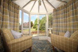 - un salon avec deux chaises et une grande fenêtre dans l'établissement Exceptional 3 Bed, Great Location in Ashby Ideal for Travellers, Short Holiday Stays And Contractors, à Brumby