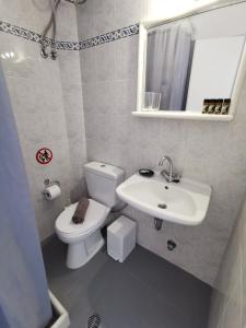 a bathroom with a white toilet and a sink at KR Apartments in Aliki