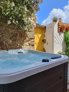 eine Whirlpool-Badewanne im Hof mit einem Gebäude in der Unterkunft Encanto Casa com Spa Jacuzzi Open Space in Tinalhas