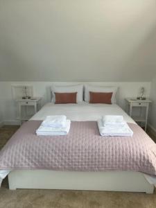 a bedroom with a large bed with two tables at Arawak in Kent