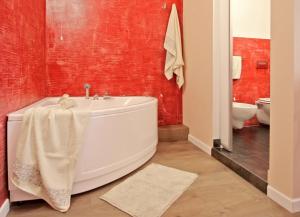 bagno con vasca e parete rossa di All'Operetta di Cagliari a Cagliari