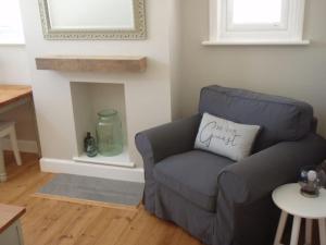 a blue chair with a pillow on it in a living room at Arawak in Kent