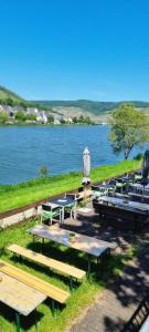 a group of picnic tables next to a body of water at Apartment Hallenbach in Zell an der Mosel