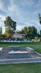 a park with a fountain in the middle of a field at Cabañas y Habitaciones Terra Nostra Complejo in General Alvear