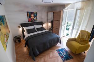 ein Schlafzimmer mit einem Bett und einem gelben Stuhl in der Unterkunft Queen Apartment Zadar in Zadar