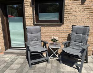 two chairs sitting on a patio next to a building at Auszeit Apartment Düsseldorf in Düsseldorf