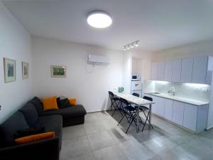 ein Wohnzimmer mit einer Couch und einem Tisch in der Unterkunft On the sea in Aschkelon