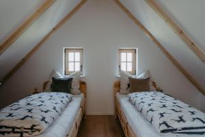 two beds in a attic room with windows at Weinberg Chalet Kokumandl in Winten