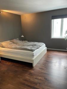 Bett in einem Schlafzimmer mit Holzboden in der Unterkunft Eiganesveien 1/sentralt,2 sov. in Stavanger