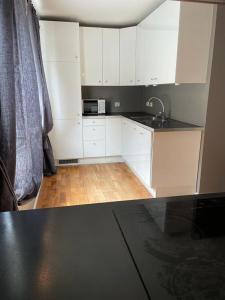 a kitchen with white cabinets and a black counter top at Eiganesveien 1/sentralt,2 sov. in Stavanger