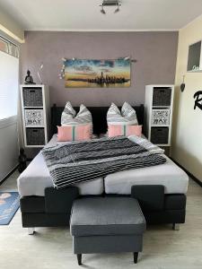 a bedroom with a large bed with pink and white pillows at WOHLFÜHL Oase in Horumersiel