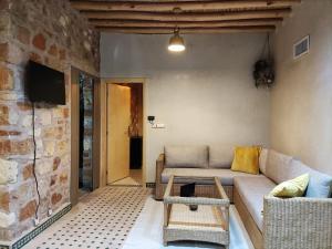a living room with a couch and a stone wall at Magnifique maison en pierre 