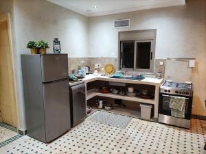 a kitchen with a refrigerator and a sink and a stove at Magnifique maison en pierre 