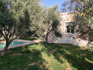a stone house with trees and a swimming pool at Magnifique maison en pierre 