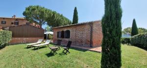 un patio con dos bancos y un edificio de ladrillo en Agriturismo Palazzo Val Del Sasso, en Villastrada