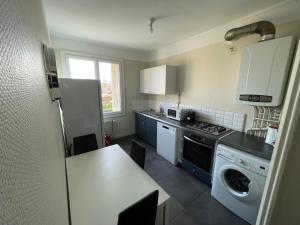 uma cozinha com uma mesa e um fogão forno superior em T4 3 Chambres proche grattes ciel, Villeurbanne, meublé em Villeurbanne