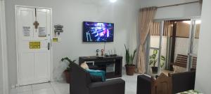 a living room with a tv on the wall at Melhor da Praia do Morro Apartamento até 10 pessoas in Guarapari