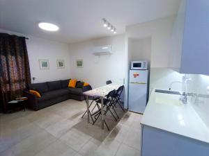 eine Küche und ein Wohnzimmer mit einer Couch und einem Tisch in der Unterkunft On the sea in Aschkelon