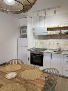 a kitchen with a wooden table with chairs and a counter at Tranquilidad y confort, Apartamento reformado en Cambrils in Cambrils