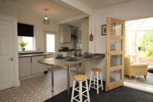 - une cuisine avec une table et des tabourets dans une pièce dans l'établissement Exceptional 3 Bed, Great Location in Ashby Ideal for Travellers, Short Holiday Stays And Contractors, à Brumby