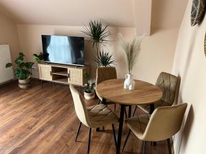 comedor con mesa, sillas y TV en Apartament BohoLook, en Nowy Sącz
