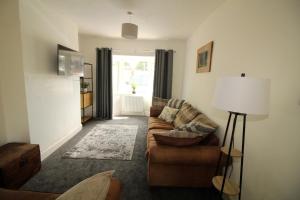 - un salon avec un canapé et une lampe dans l'établissement Exceptional 3 Bed, Great Location in Ashby Ideal for Travellers, Short Holiday Stays And Contractors, à Brumby